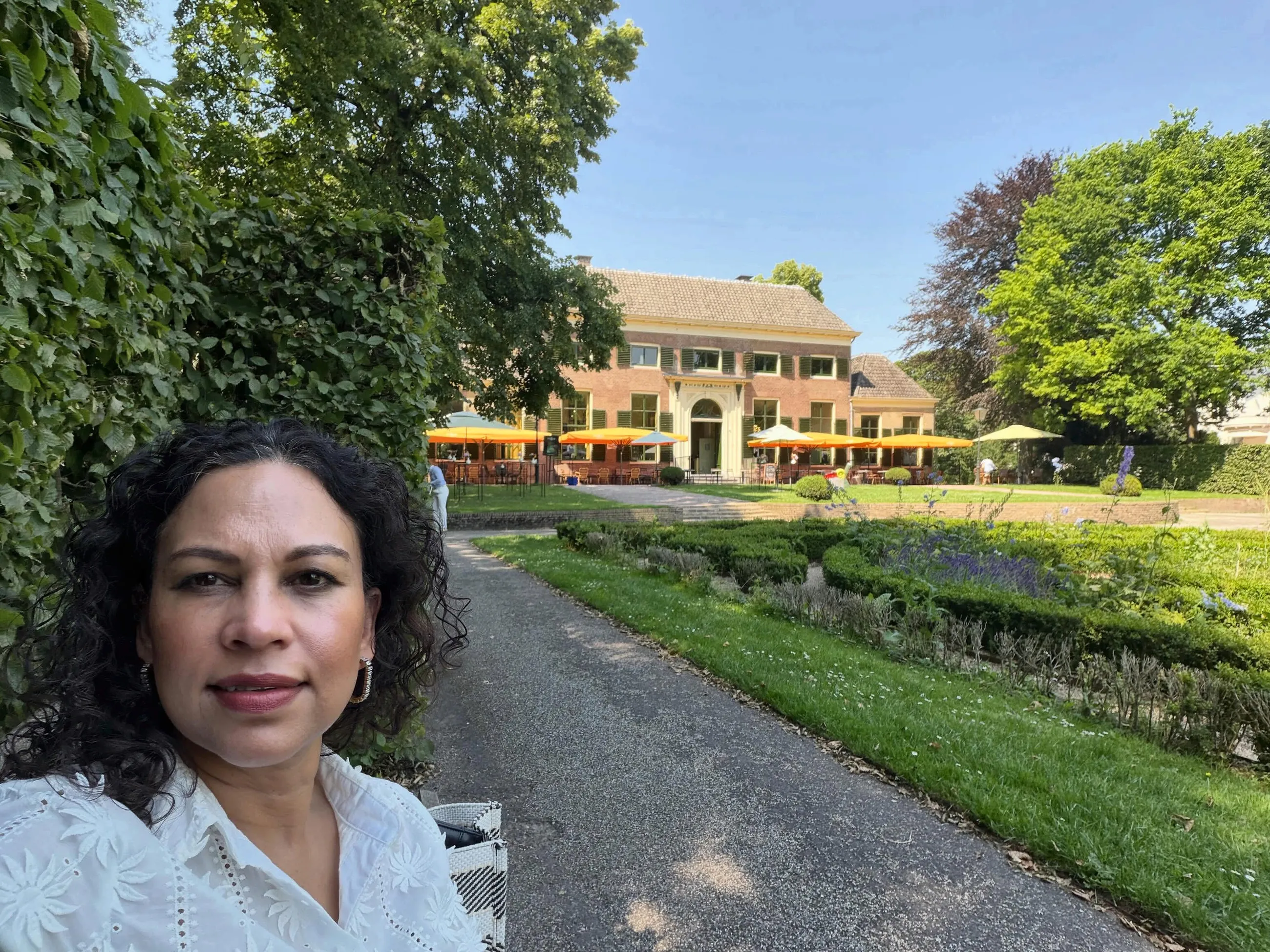 Angela lacht in de zon voor een buitenlocatie