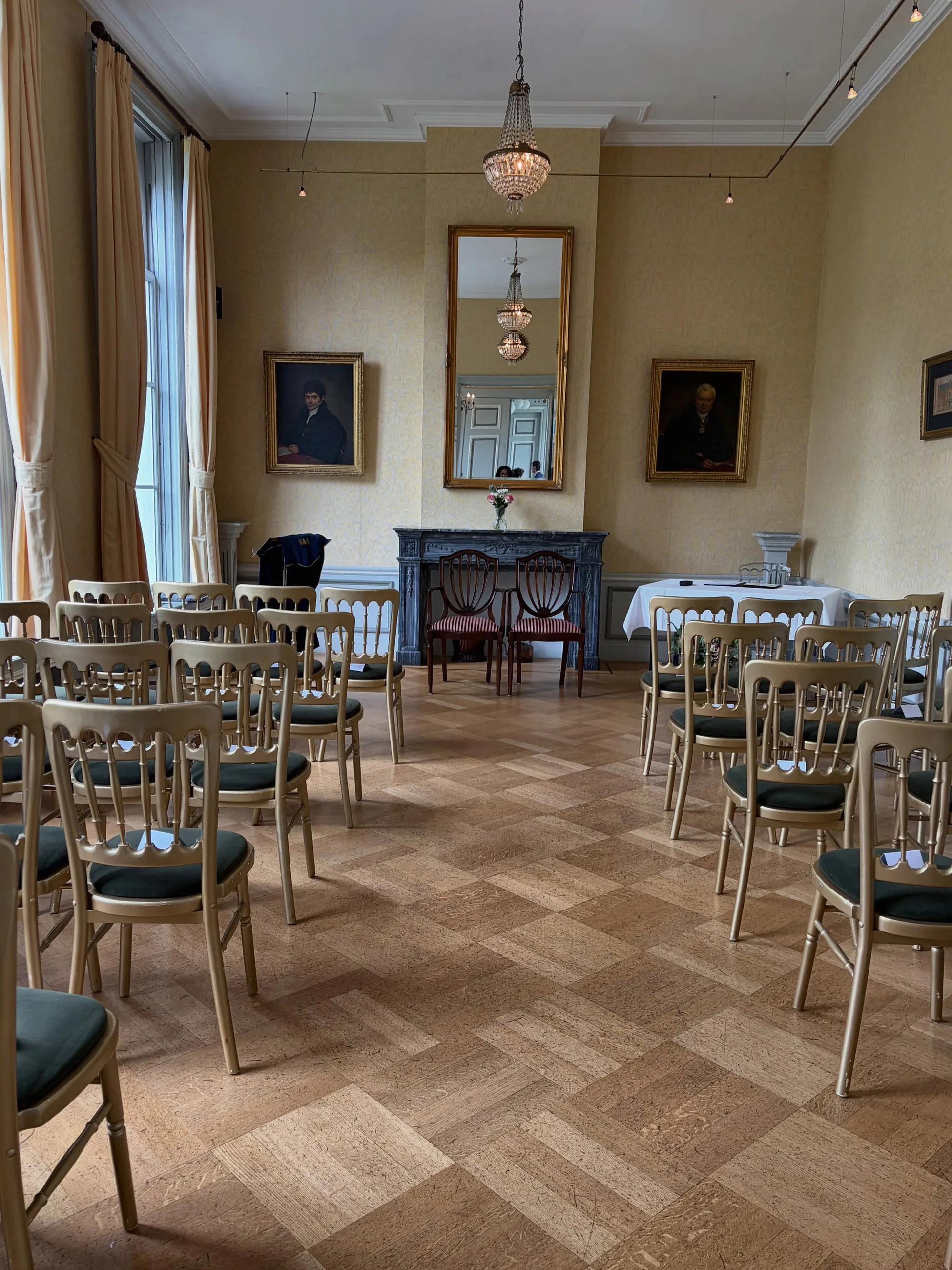 Lege trouwzaal met stoelen op visgraatparket, klaar voor de ceremonie