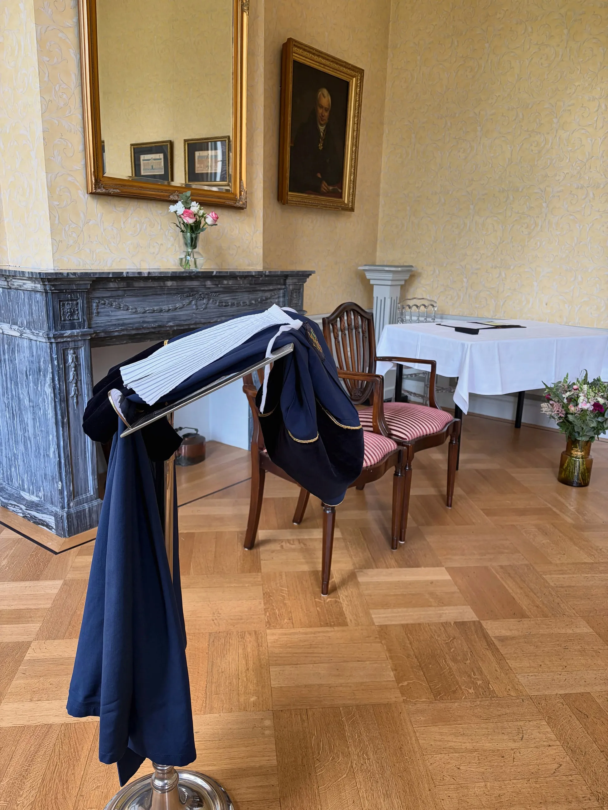 Angela's toga hangt klaar over een stoel in een historische trouwzaal