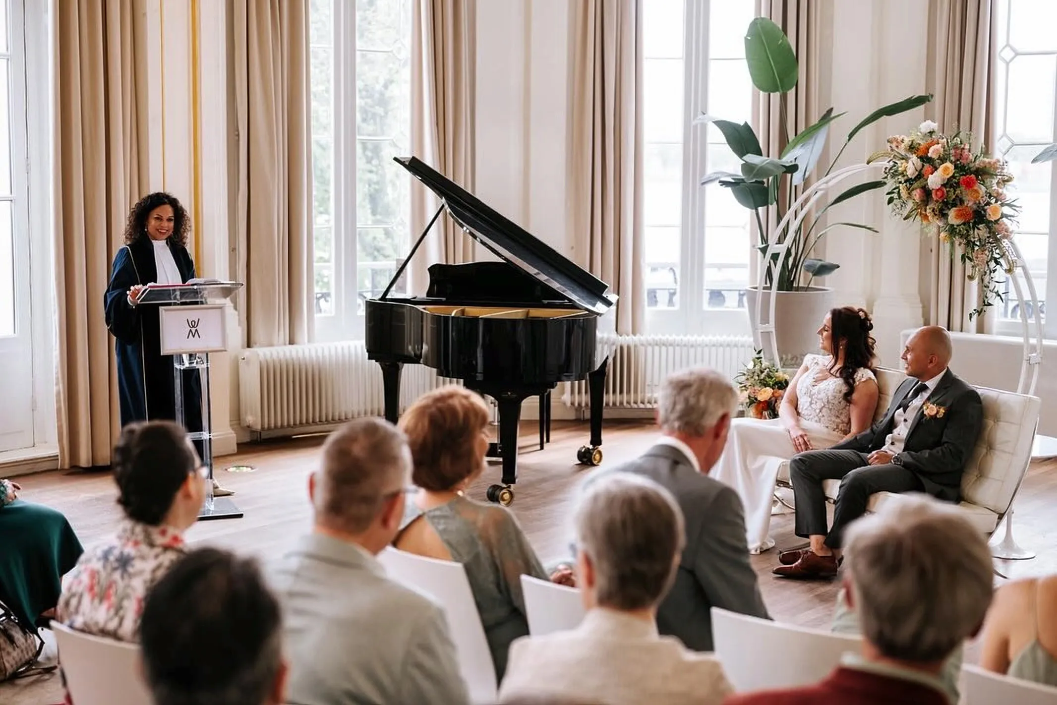 Angela in toga lacht achter de lessenaar tijdens een ceremonie